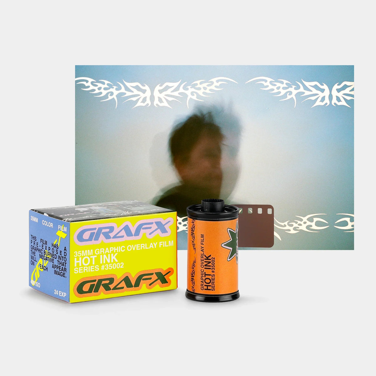 A Grafx hot ink film product display featuring a yellow and blue 25mm film box, an orange film roll, and a brown film strip in front of a blurred demonstration photo with white graphic overlays.