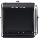 A Hasselblad medium format camera body shown from the back, featuring a large black rear screen, silver metal side frames, and the 'HASSELBLAD' brand name in gold lettering above the screen.