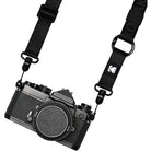 Black camera with a strap on a white background