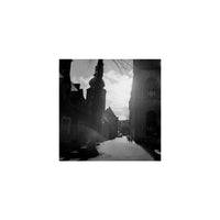 High-contrast black-and-white street scene captured on KONO! CINIS 400 film with visible grain and deep shadows.