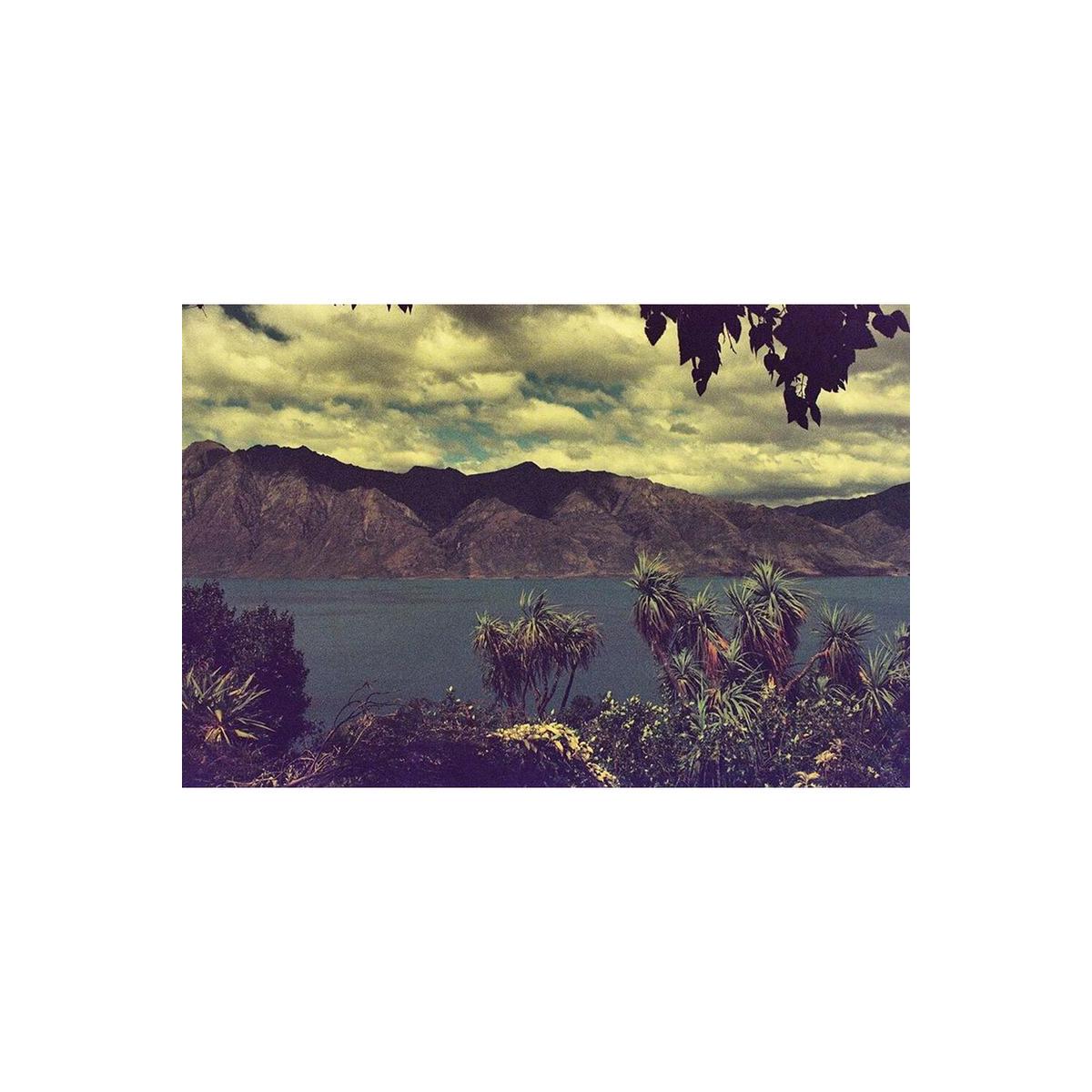 Landscape shot of mountains and a lake with pink-tinted, candy-like color shifts from KONO! Candy 200 35mm film.