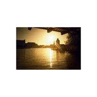 Golden sunset over a city waterfront captured on KONO! Moonstruck 200 35mm film with soft, warm light flares.