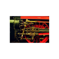 Close-up of a red steam locomotive wheel with brass mechanical linkages, captured on KONO! Moonstruck 200 color film.