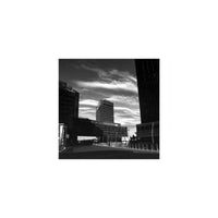 High-contrast black-and-white cityscape with dramatic clouds, captured on KONO! Rekorder 35mm experimental film.
