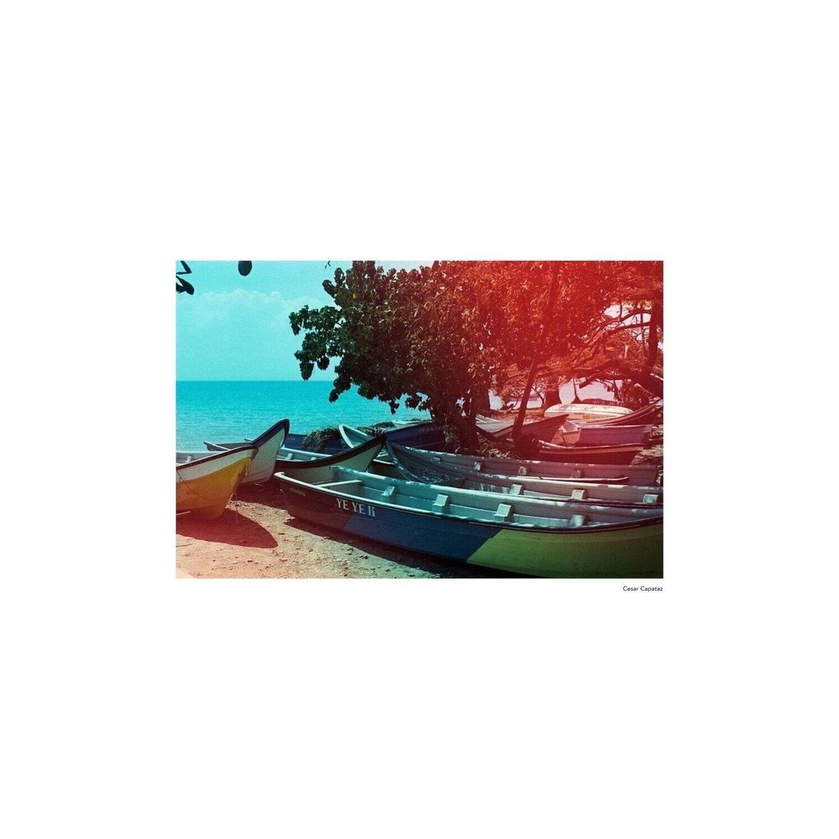 Colorful boats on a sandy beach featuring KONO! Sunstroke 35mm film's signature warm light leaks and vibrant color shifts.