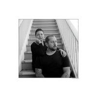 Black and white portrait of a couple sitting on outdoor stairs, captured with Kentmere Pan 100 film.