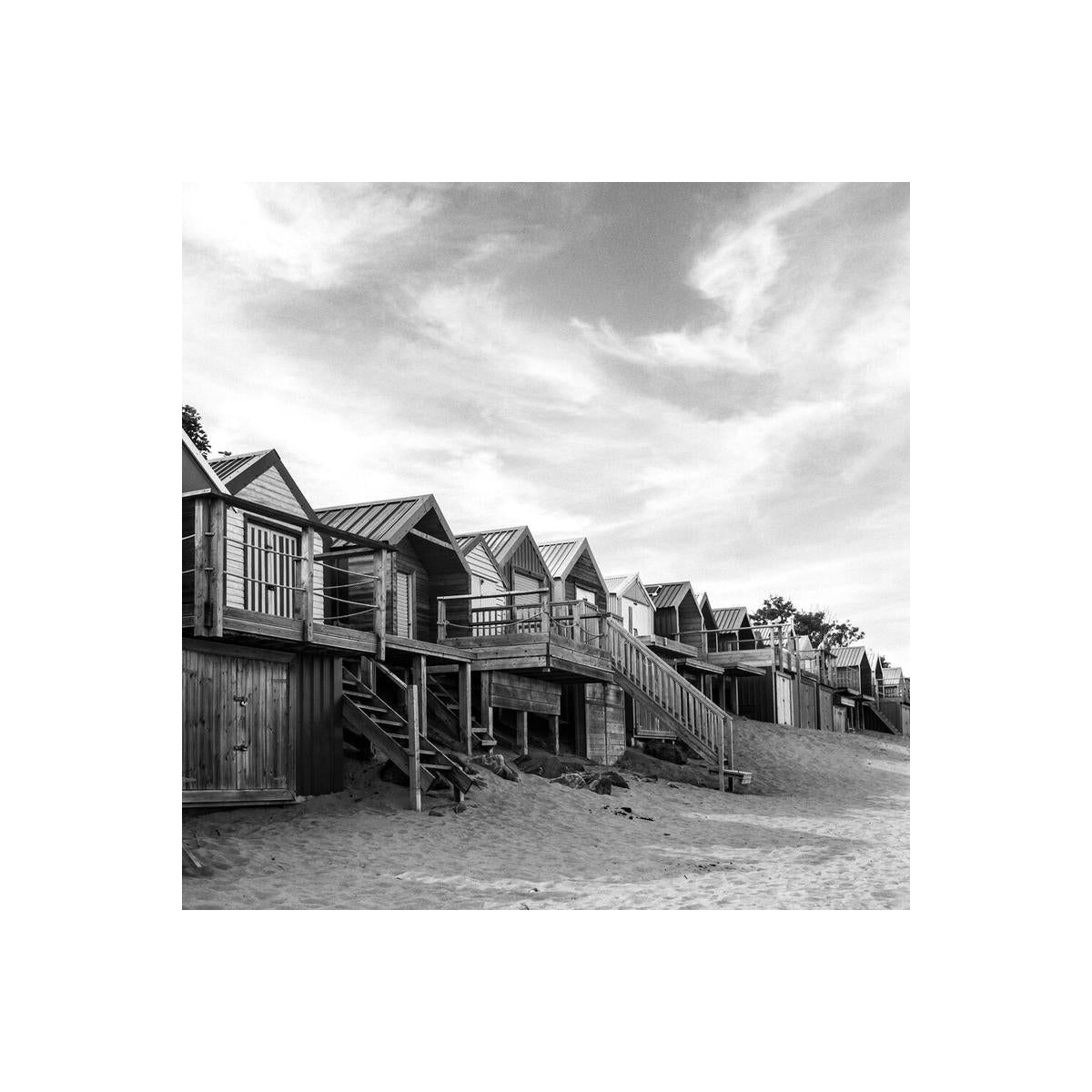 Black and white landscape shot of wooden beach huts on stilts, captured with sharp detail and smooth tonal range.