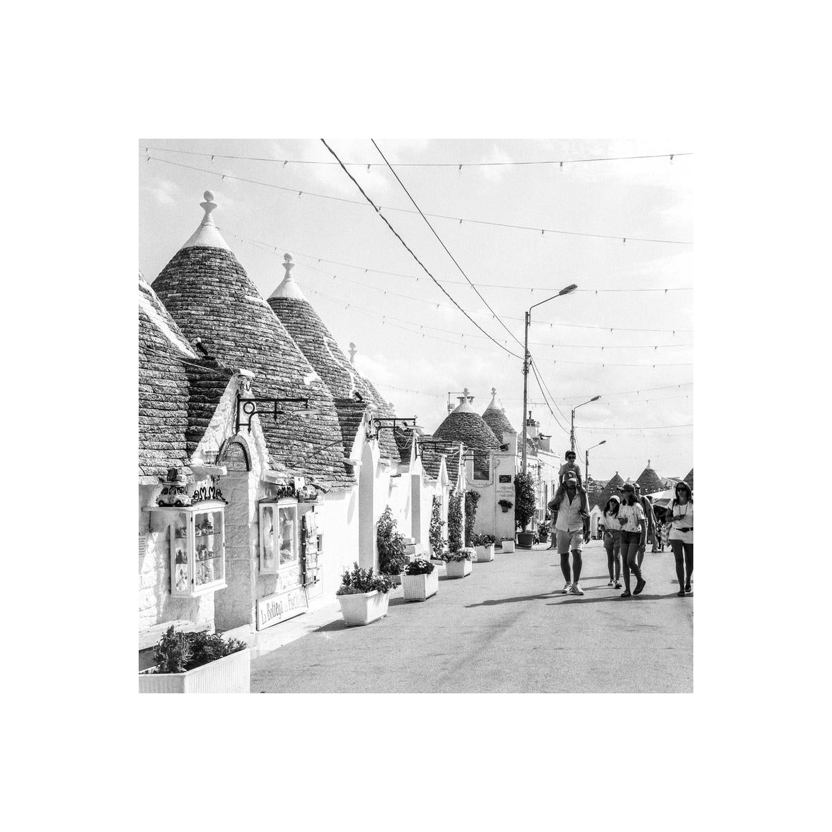 Black and white street scene featuring traditional conical trulli houses in Alberobello, captured on Kentmere Pan 400 film.