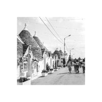 Black and white street scene featuring traditional conical trulli houses in Alberobello, captured on Kentmere Pan 400 film.