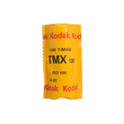 Single roll of Kodak TMAX 100 ISO 120 black and white film in its iconic yellow protective foil wrapper.