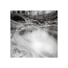 Black and white long exposure of a swirling forest stream captured on Kodak TMAX 100 120 film with fine grain detail.