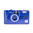 Glossy blue Kodak M38 35mm film camera with a fixed-focus lens, built-in flash, and white branding on a lightweight plastic body.