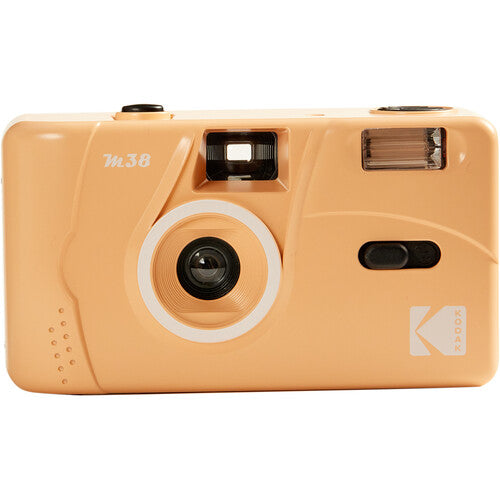 Peach-colored Kodak M38 35mm reusable film camera with a fixed-focus lens, built-in flash, and compact plastic body.