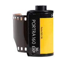 A roll of Portra 160 36 film with a black and yellow label, showing the film strip partially unrolled on a white background.