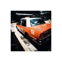 Orange and white Hong Kong taxi captured on 120 film with warm, nostalgic tones and rich, visible grain.