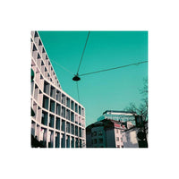 Modern building architecture captured with LomoChrome Purple film, featuring surreal teal sky and high-contrast shadows.