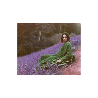 Woman in a green sweater sitting in a field rendered in surreal purple tones by LomoChrome Purple 120 film.