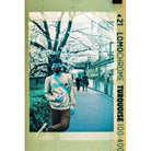 LomoChrome Turquoise 110 film print showing a person on a path with vibrant cyan, blue, and gold color shifts.