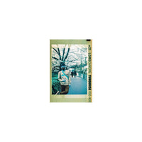 LomoChrome Turquoise 110 film print showing a person on a path with vibrant cyan, blue, and gold color shifts.