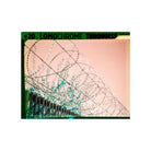 Barbed wire fence captured on LomoChrome Turquoise 110 film with distinct cyan and emerald color shifts.