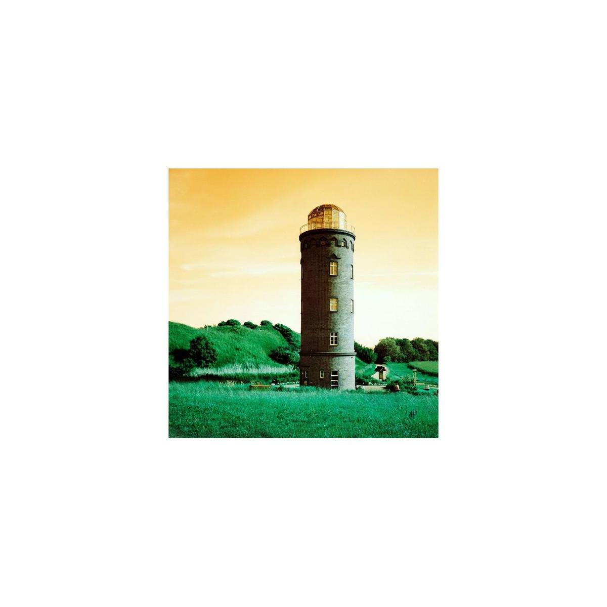 Lighthouse in a field rendered with LomoChrome Turquoise film, featuring vibrant green grass and a golden sky.