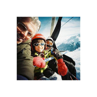 A man and child in ski gear taking a selfie on a chairlift, captured with vibrant colors on medium-format film.