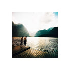 Two men standing on a wooden dock overlooking a lake and mountains, captured with vibrant Lomography 100 120 film.