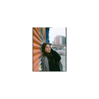 Portrait of a woman leaning against an orange corrugated wall, captured with vibrant Lomography 400 120 color film.