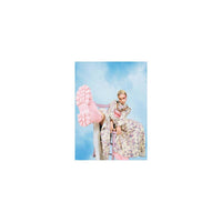 Person sitting on a chair with pink shoes in front of a blue sky