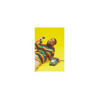 Man in a striped shirt holding a vintage rotary phone against a vibrant yellow background, captured on Lomography 400 film.