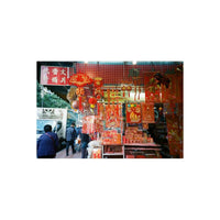 Street market stall decorated with vibrant red Chinese New Year ornaments, lanterns, and traditional paper decorations.