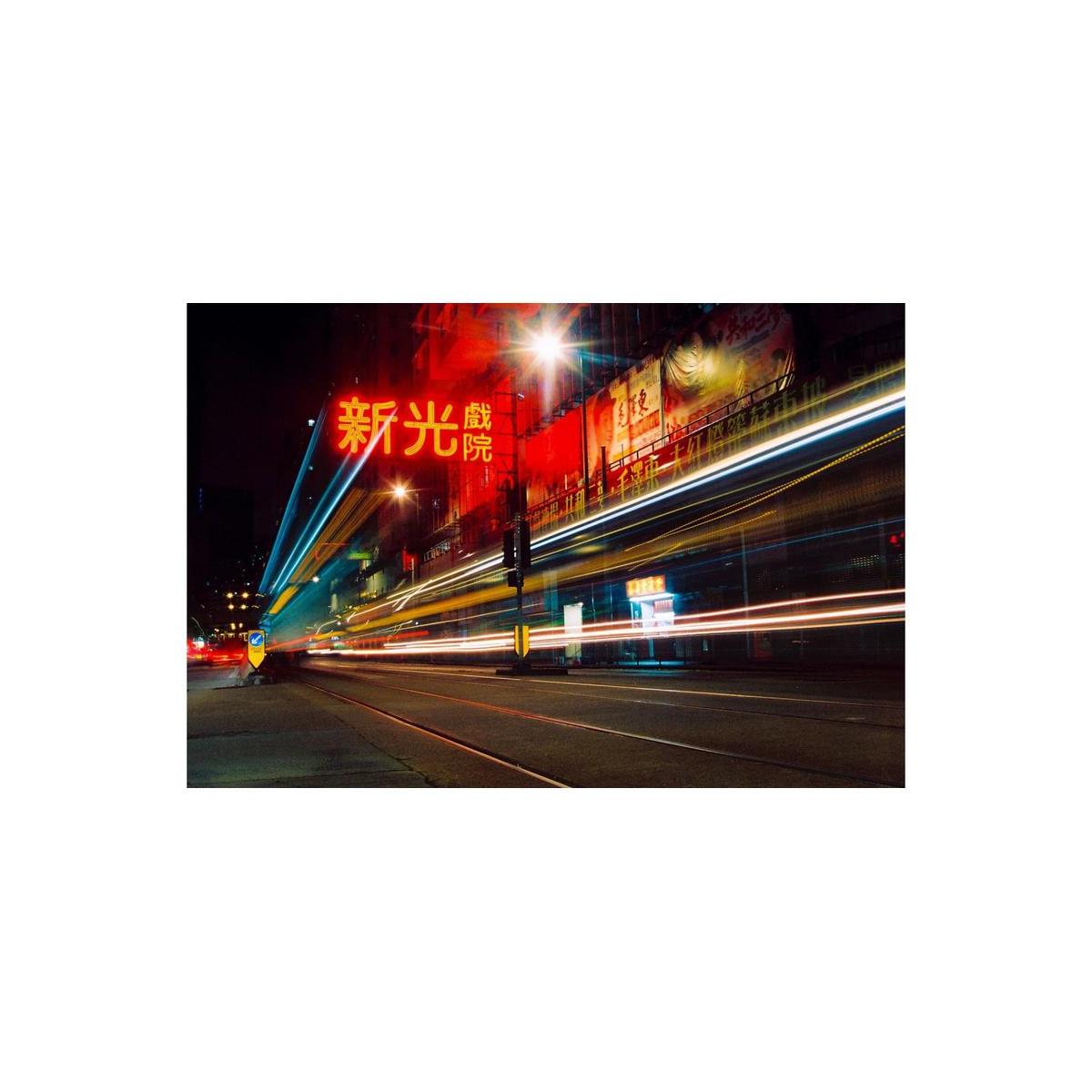 Nighttime city street with long-exposure light trails and vibrant red neon signage captured on 35mm film.