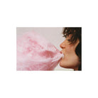 Profile view of a person eating bright pink cotton candy, captured with the saturated, grainy aesthetic of Lomography 800 film.