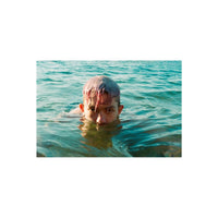 Person with pink hair swimming in turquoise water, captured with the bold colors and grain of Lomography 800 35mm film.