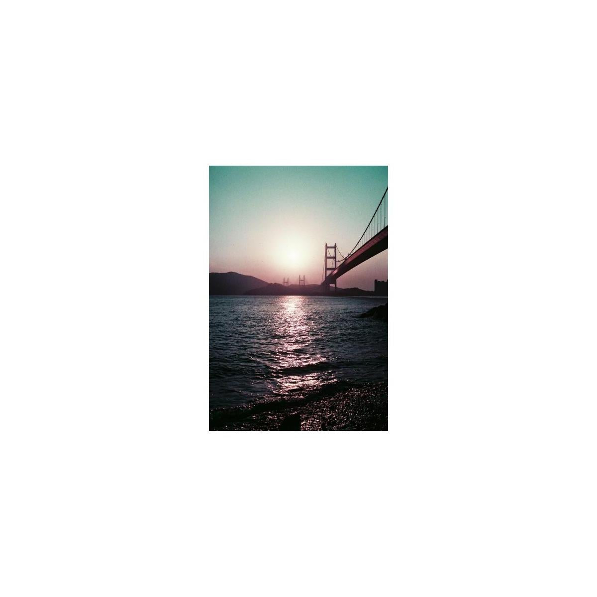 Golden Gate Bridge at sunset with vintage purple and teal color shifts captured on 35mm film.