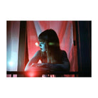 Woman leaning on a balcony at night, captured with vibrant red and purple color shifts characteristic of LomoChrome film.