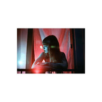 Woman leaning on a balcony at night, captured with vibrant red and purple color shifts characteristic of LomoChrome film.