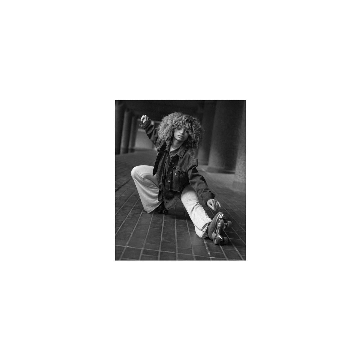 Black and white portrait of a person on roller skates, captured with a cinematic, grainy film aesthetic.