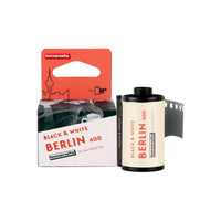 Lomography Berlin Kino 400 35mm black and white film roll and its orange and white cardboard box packaging.