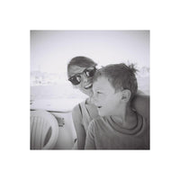 Black and white photo of a woman and a young boy sitting close together.
