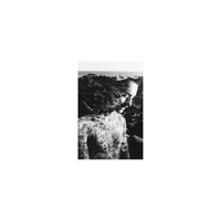 Double exposure black and white portrait of a tattooed man blended with a rocky coastline, shot on Lomography Lady Grey.