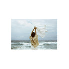 Person standing on a beach holding a white cloth, captured with the muted, high-contrast aesthetic of Lomography Metropolis.