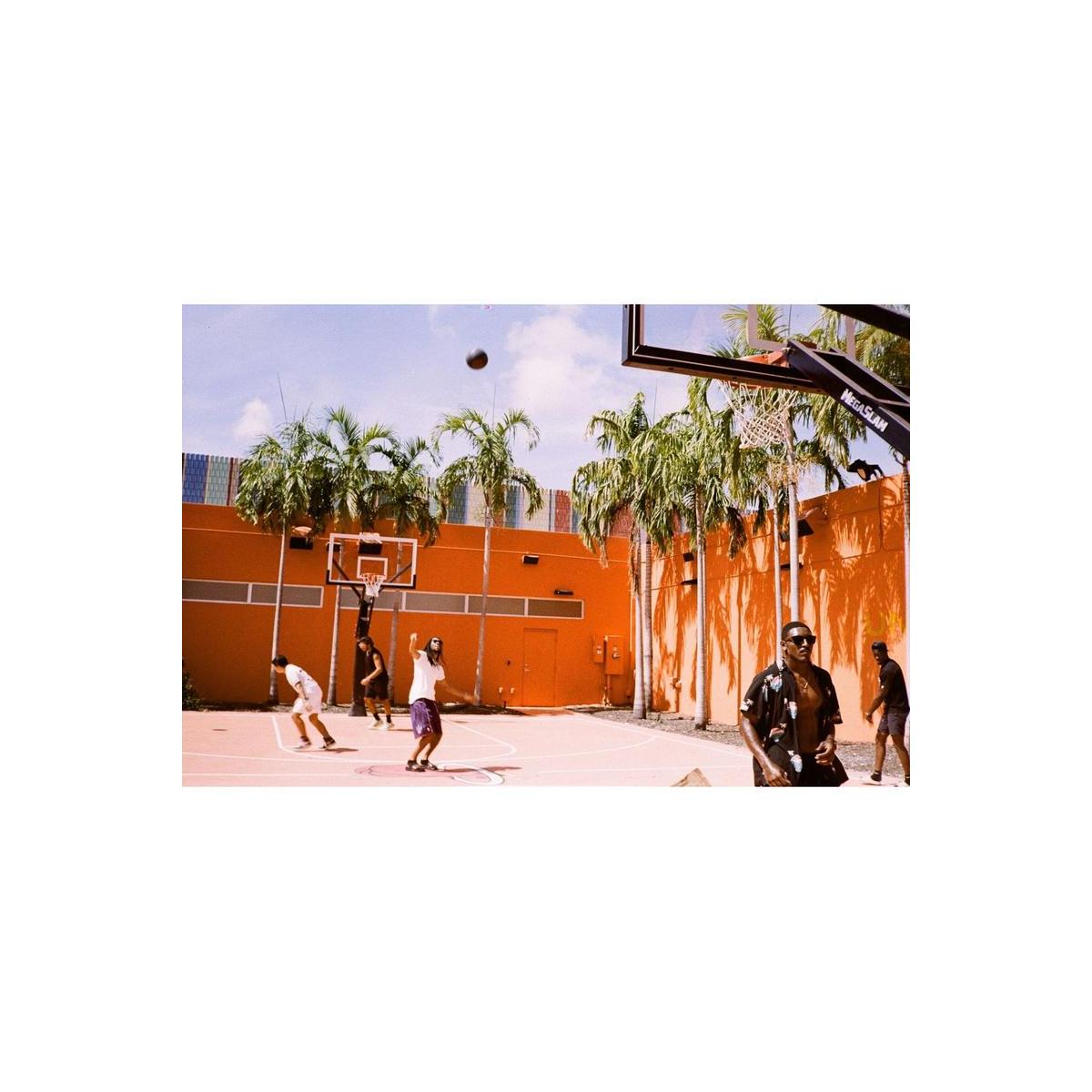 People playing basketball on an orange court, captured with the muted, high-contrast tones of Lomography Metropolis film.