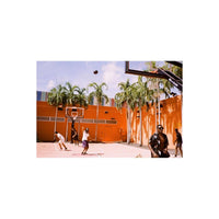 People playing basketball on an orange court, captured with the muted, high-contrast tones of Lomography Metropolis film.