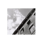 Black and white low-angle shot of a brick building facade against a cloudy sky, captured on Lomography Orca 110 film.