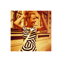 Woman in a black and white striped dress captured with warm red and orange tones from Lomography Redscale 120 film.