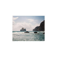 Vivid coastal landscape shot on Lomography Tiger 200 110 film featuring rocky cliffs, blue ocean waves, and bright sky.