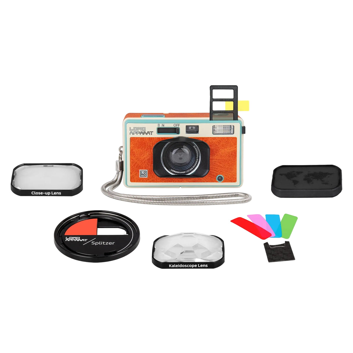 A retro-style Polaroid camera with a textured orange body, cream top, and black lens, shown with multiple accessories including a close-up lens, color filter, kiosk lens, strap, and color slides on a white background.