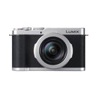 Silver and black camera with the logo name of Lumix on the front on a background
