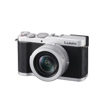 Black and silver camera with the word Lumix on it with a white background